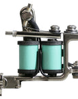 Side profile of a Jonesy-style one-off coil liner tattoo machine featuring mint green custom wrapped coils, black wiring, and compact handmade frame.