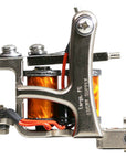 Jonesy-style one-off coil liner tattoo machine handmade by Lucky Supply featuring bright orange wrapped 1¼” coils, 5/16 coil cores, compact silver frame, and tuned liner setup.