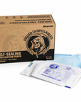 A box of Druid Disposables self-sealing sterilization pouches, shown with two individual foil pouches in front on a white background.