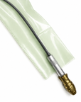 A close-up of a black cable with a brass and silver connector, resting on a translucent pale green protective sleeve against a white background.