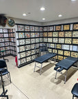 Tattoo studio interior with tattoo designs on walls, chairs, and equipment.