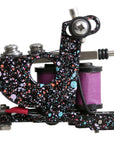 Tattoo machine with colorful speckled design on a white background