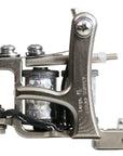Jonesy-style one-off coil liner tattoo machine handmade by Lucky Supply featuring reflective wrapped 1¼” coils, compact silver frame, and tuned liner setup.