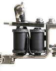Side profile of a Jonesy-style Flat Black coil liner tattoo machine with flat black coil wraps, drilled frame holes, and traditional handmade construction.