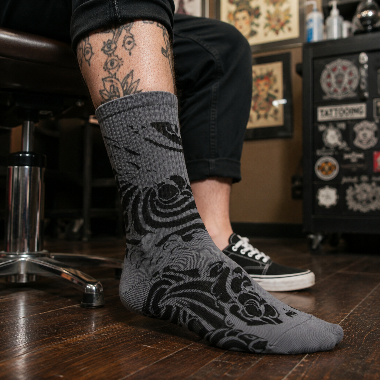 A single crew sock with a dark gray and black abstract wave-like pattern, shown against a plain white background.