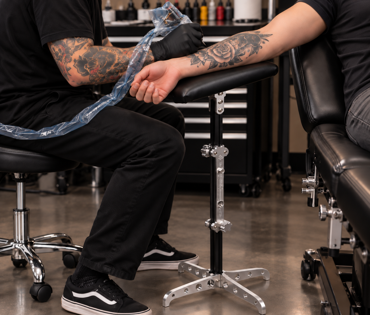 Professional tattoo artist using Lucky Supply Portable Arm Rest while tattooing client