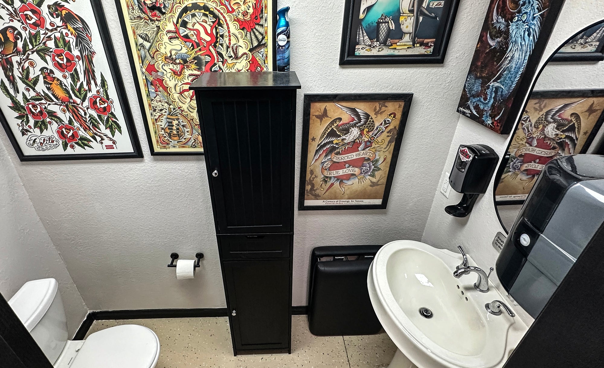 Bathroom with tattoo flash on the wall and a sink.