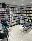 Tattoo studio with various tattoo designs on the walls, chairs, and a table.