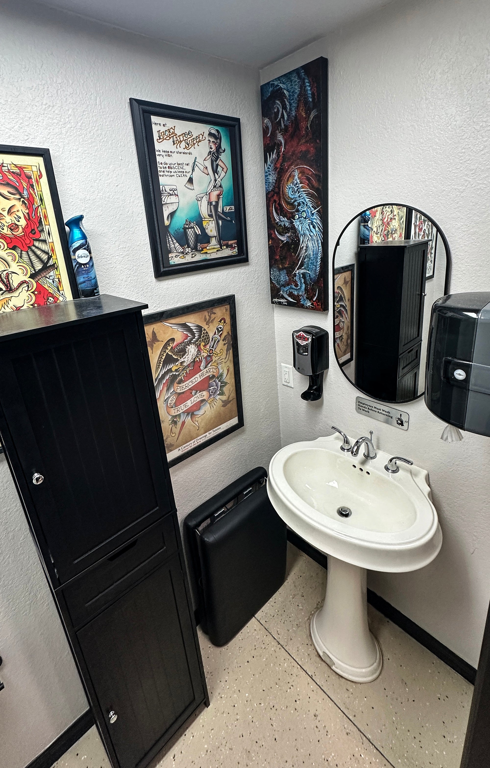 Bathroom with a sink, cabinets, and framed artwork on the wall.
